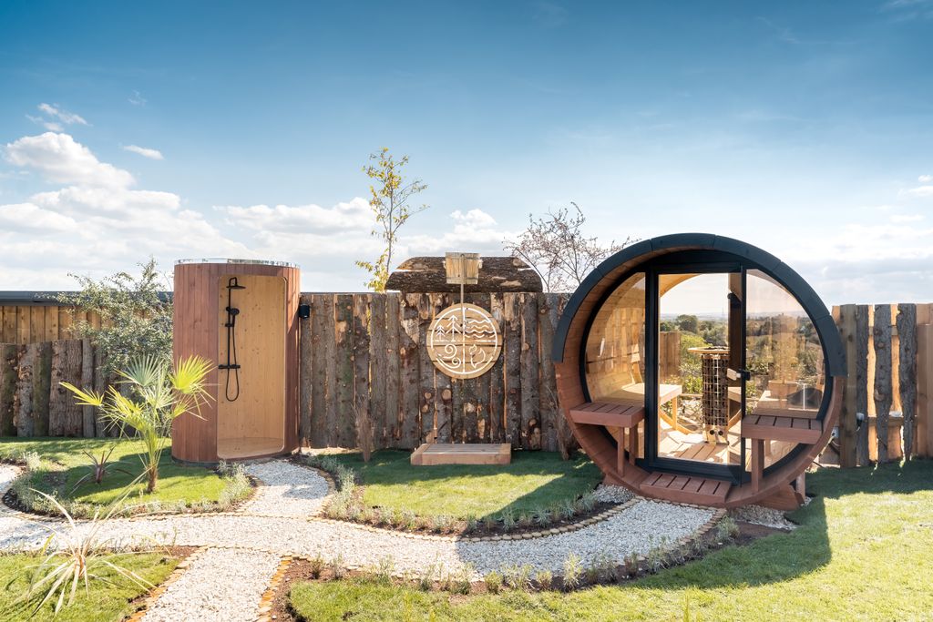 a barrel sauna and outdoor shower in a spa garden 