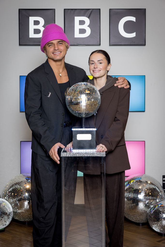 Nikita Kuzmin and Amber Davies standing with the Glitterball trophy
