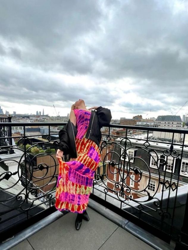 Kylie Minogue in multicoloured dress on a balcony