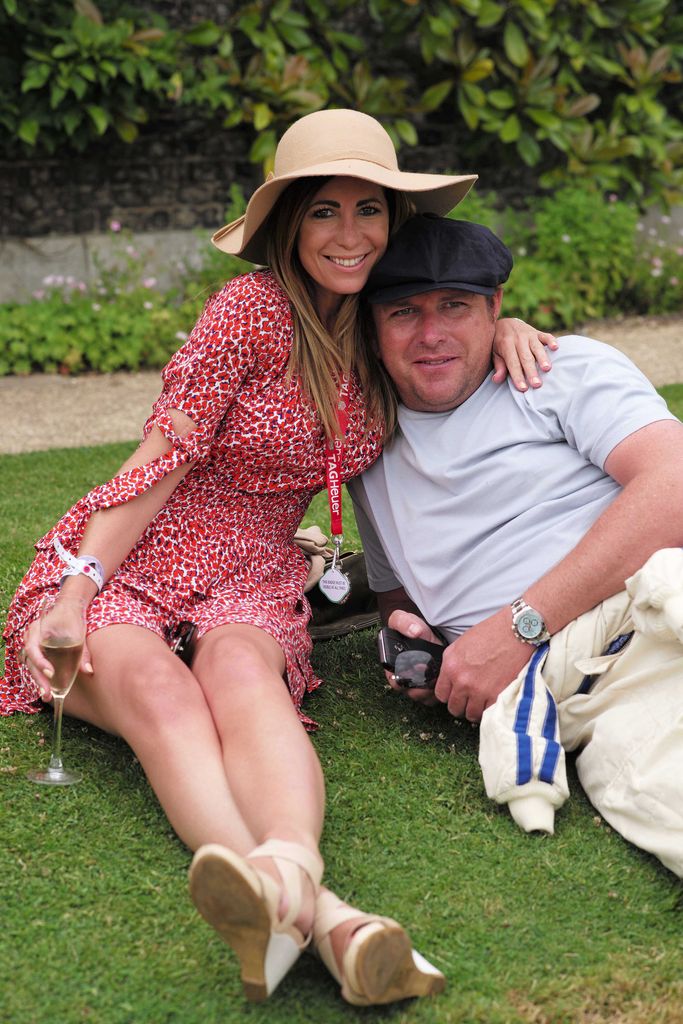Louise in a red dress with her arm lovingly draped around James Martin's neck