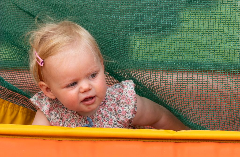 A baby playing in a bouncy castle