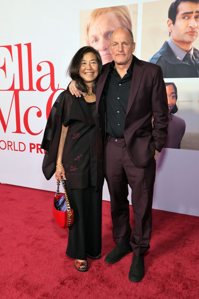 Laura Louie in black dress and Woody Harrelson in burgundy suit at the world premiere of 20th Century Studios' Ella McCay at the El Capitan Theatre