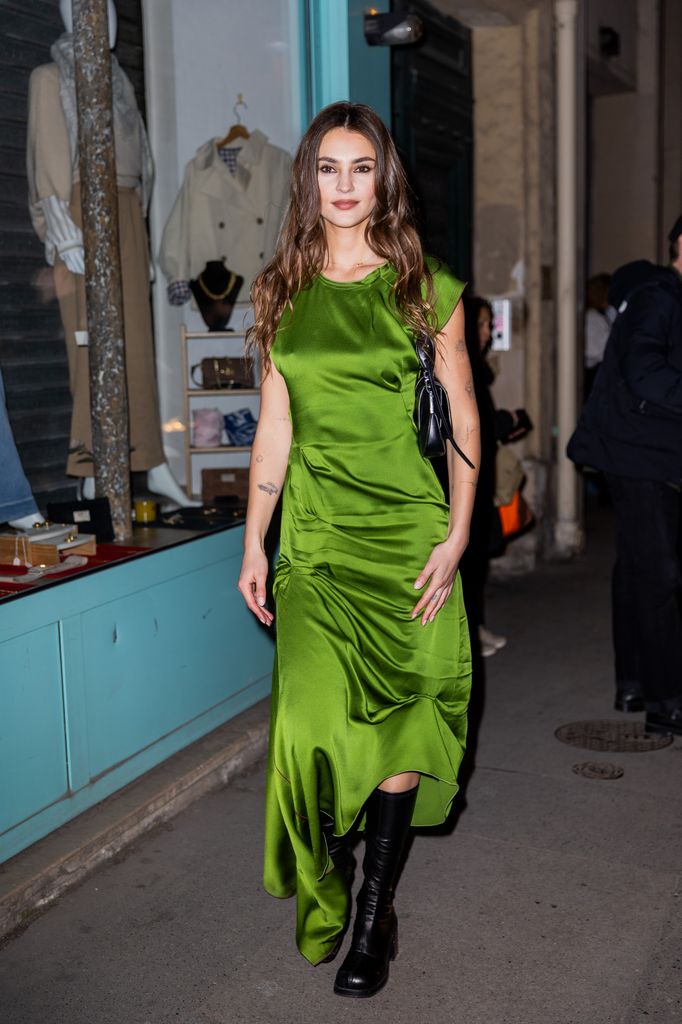 Stefanie Giesinger wears green sleeveless dress, black boots, bag outside Victoria Beckham during the Womenswear Fall/Winter 2025/2026 as part of Paris Fashion Week