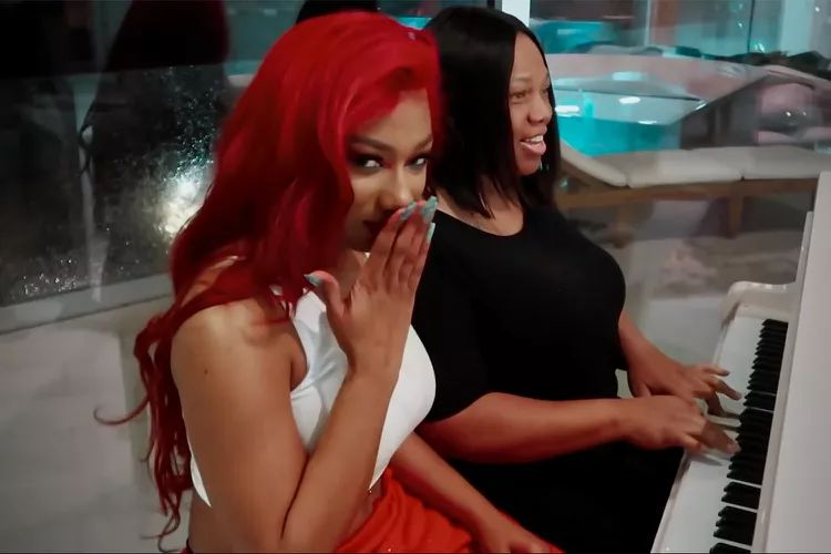 Megan Thee Stallion sits with her mom Holly on a piano bench