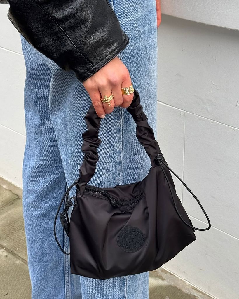 Woman holding black handbag