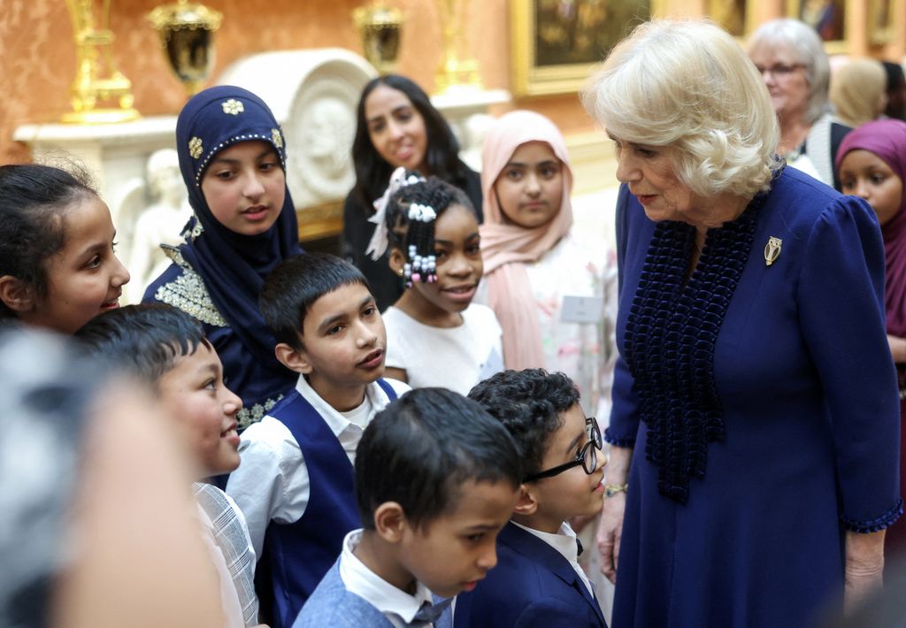 Britain's Queen Camilla (R) speaks with children during a reception for the BBC's 500 Words Finalists at Buckingham Palace