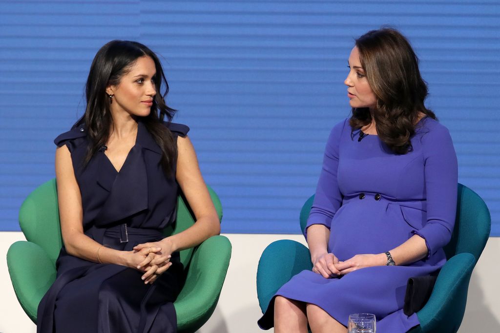 Princess Kate and Meghan Markle sitting and looking at one another