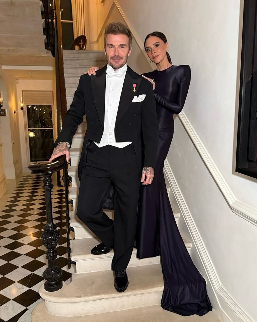 Victoria Beckham and David Beckham posing on the stairs