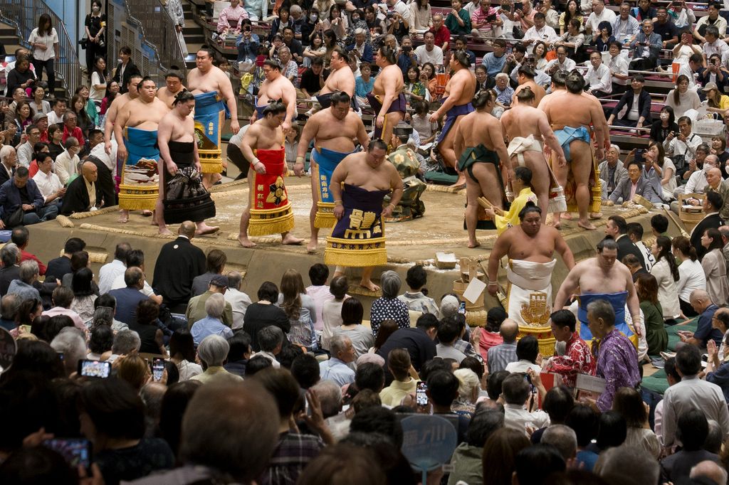 A photo of sumo wrestlers on stage in traditional dress