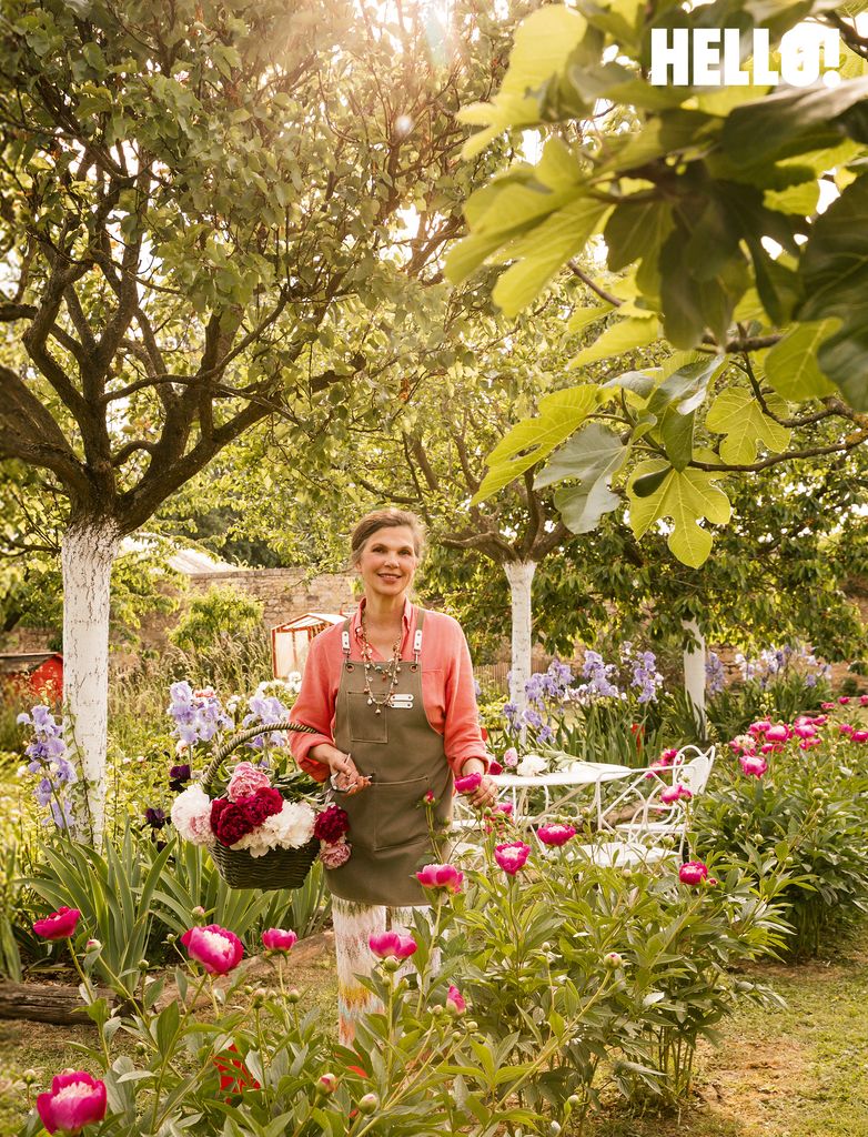 Anne in the peony garden holding a basket of flowers at the Château de Sourches