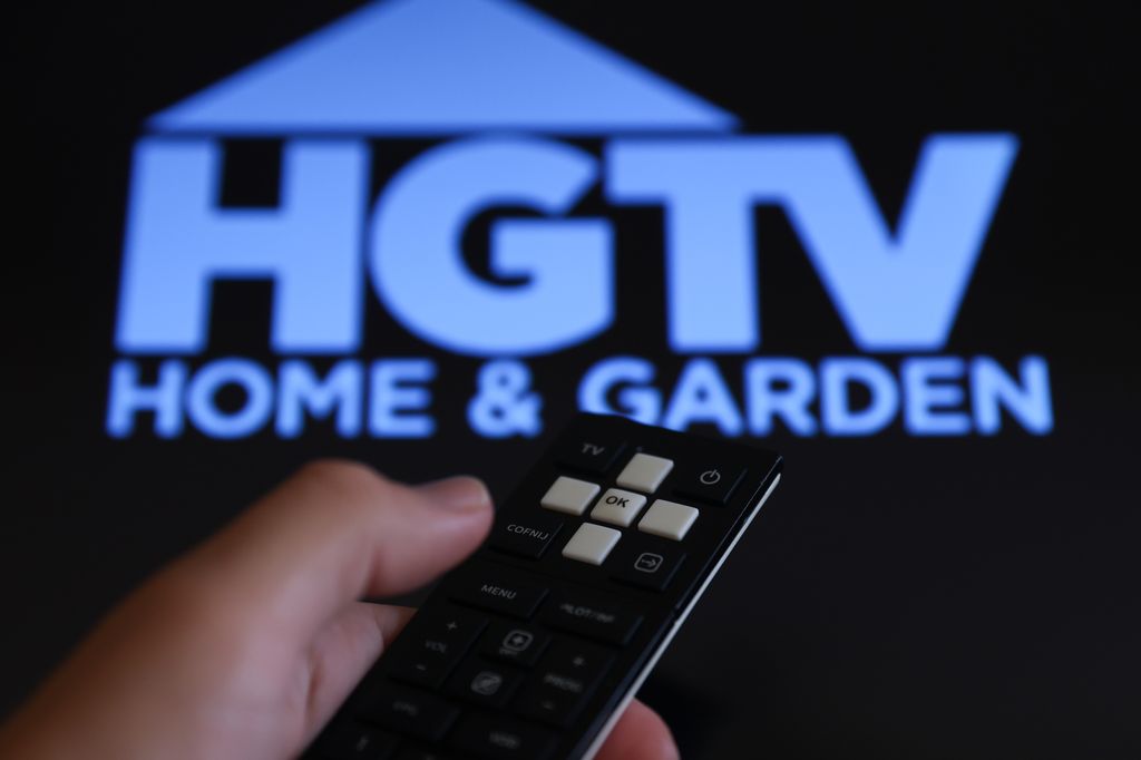 HGTV logo displayed on a tv screen and a remote control are seen in this illustration photo taken in Poland on August 7, 2024