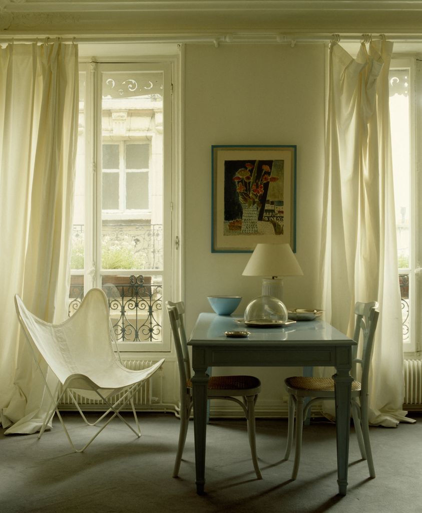 Une table à manger et des fenêtres avec une chaise Butterly 
