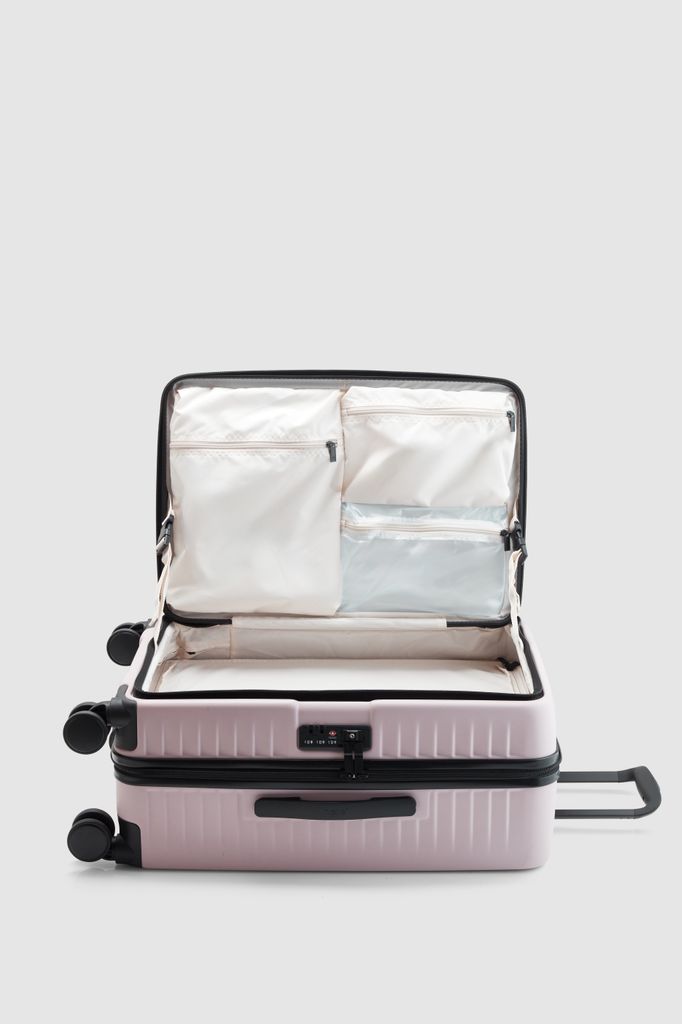 Product shot of Nere Venture cabin suitcase in pink laying flat and open on its side