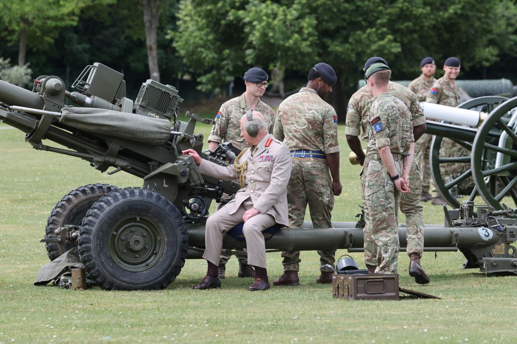 King Charles prepares to fire an artillery piece during a visit to the regiments headquarters in Lark Hill