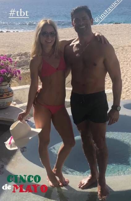 Kelly Ripa and Mark Consuelos pose on the beach in swimwear during a family vacation