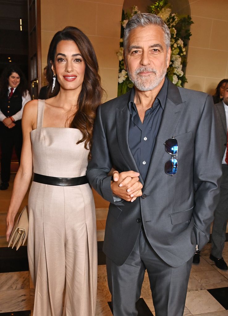 George Clooney dan Amal berpegangan tangan