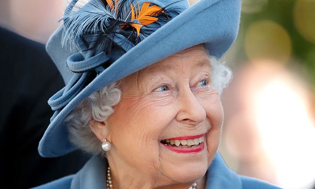 The Queen smiles in blue floral hat