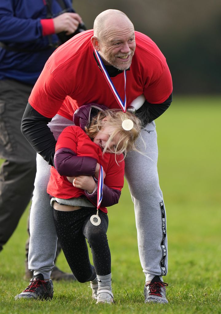 Mike Tindall in red charity shirt hugging daughter Lena Tindall during Rugby for Heroes Fun Run  
