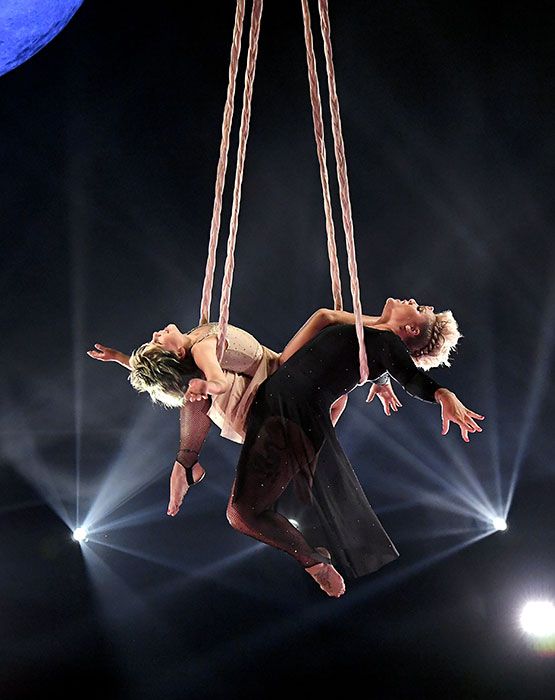 Pink and another individual hanging from ropes during an aerial performance