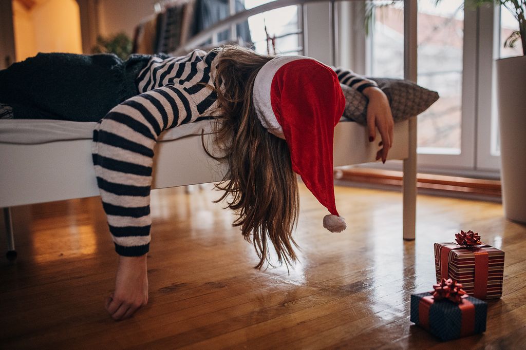 Young woman sleeping in bed after celebrating new year last night.