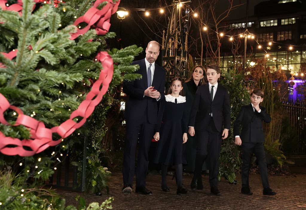 Prince William, Prince of Wales, Catherine, Princess of Wales with their children Prince George, Princess Charlotte and Prince Louis look at messages on the Kindness Tree ahead of the Together At Christmas carol service