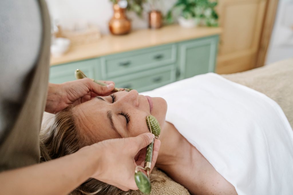 massage with gemstone rollers to woman at beauty spa
