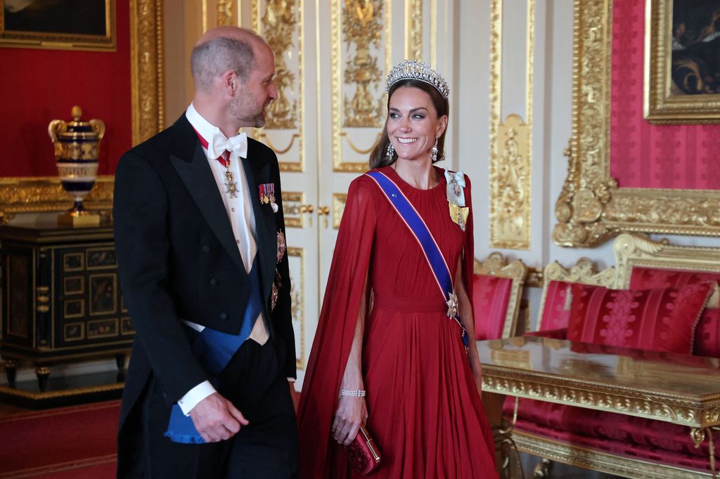 Kate Middleton smiling in red dress and tiara 