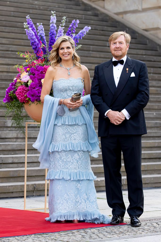 Rainha Máxima por passos em vestido azul com o Rei Willem-Alexander 