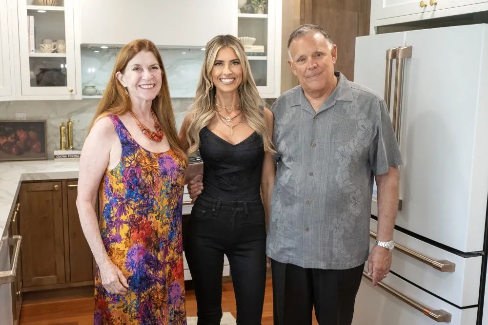 Christina Hall (C) with her mom Laurie and dad Paul in their kitchen