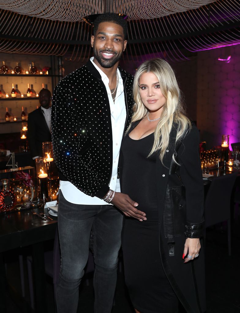 A pregnant Khloe with Tristan Thompson both are smiling at the camera
