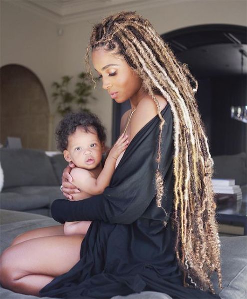 ciara holding baby son looking away from camera