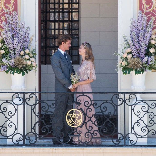 Pierre Casiraghi and Beatrice Borromeo holding hands on a balcony