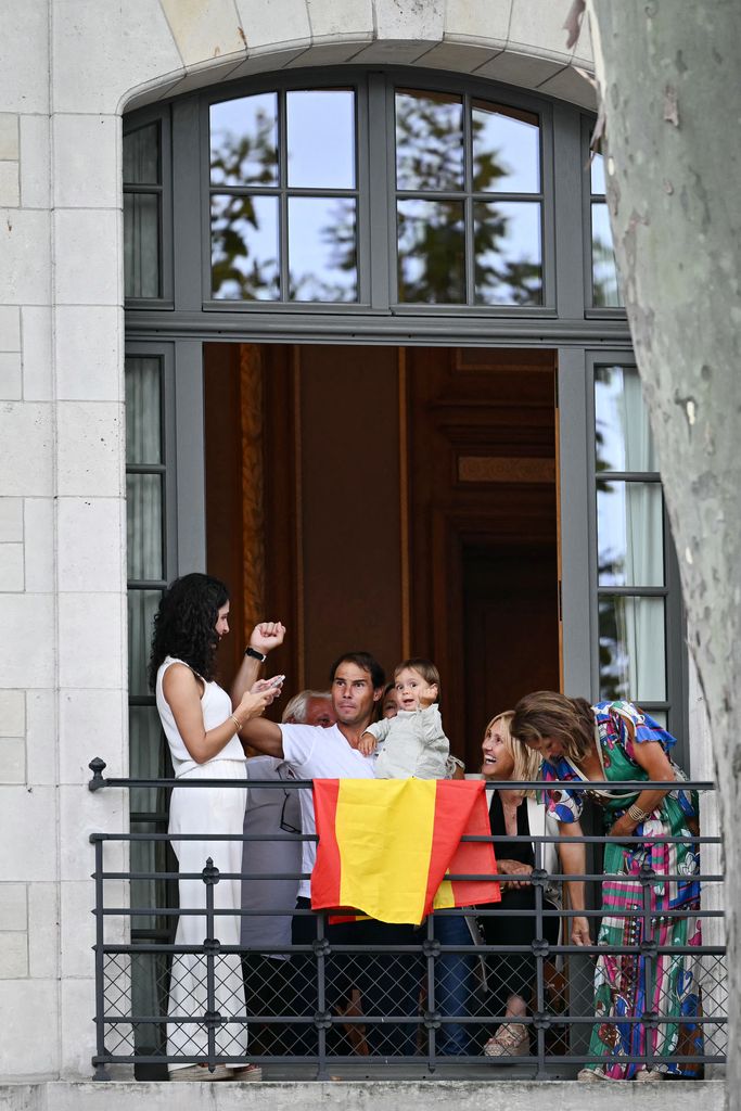 Spain's tennis player Rafael Nadal, his wife Maria Francisca Perello, and their son Rafa Junior watch from a balcony the opening ceremony of the Paris 2024 Olympic Games in Paris