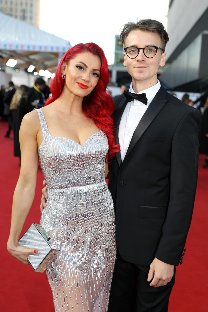 Dianne Buswell in a silver dress on the red carpet with Joe Sugg