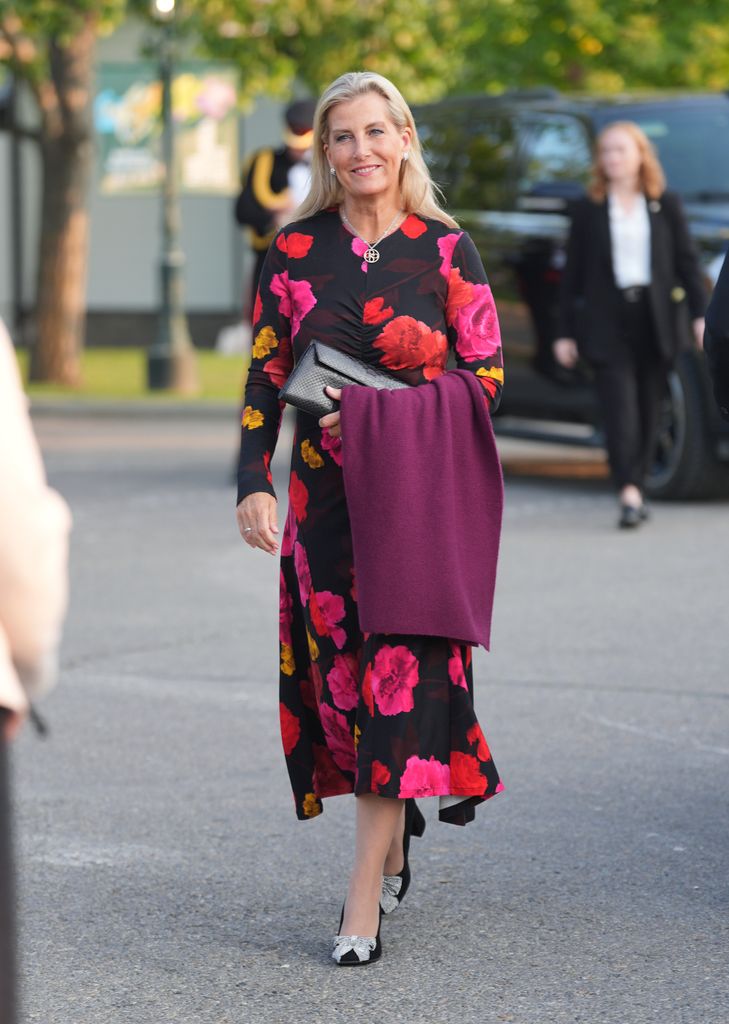 The Duchess of Edinburgh arriving in black dress with red and pink flowers on