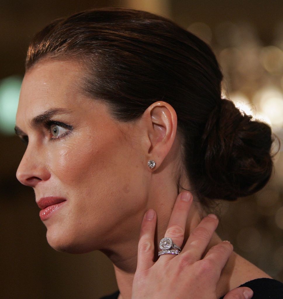 Brooke Shields side on with ring-clad hand on neck