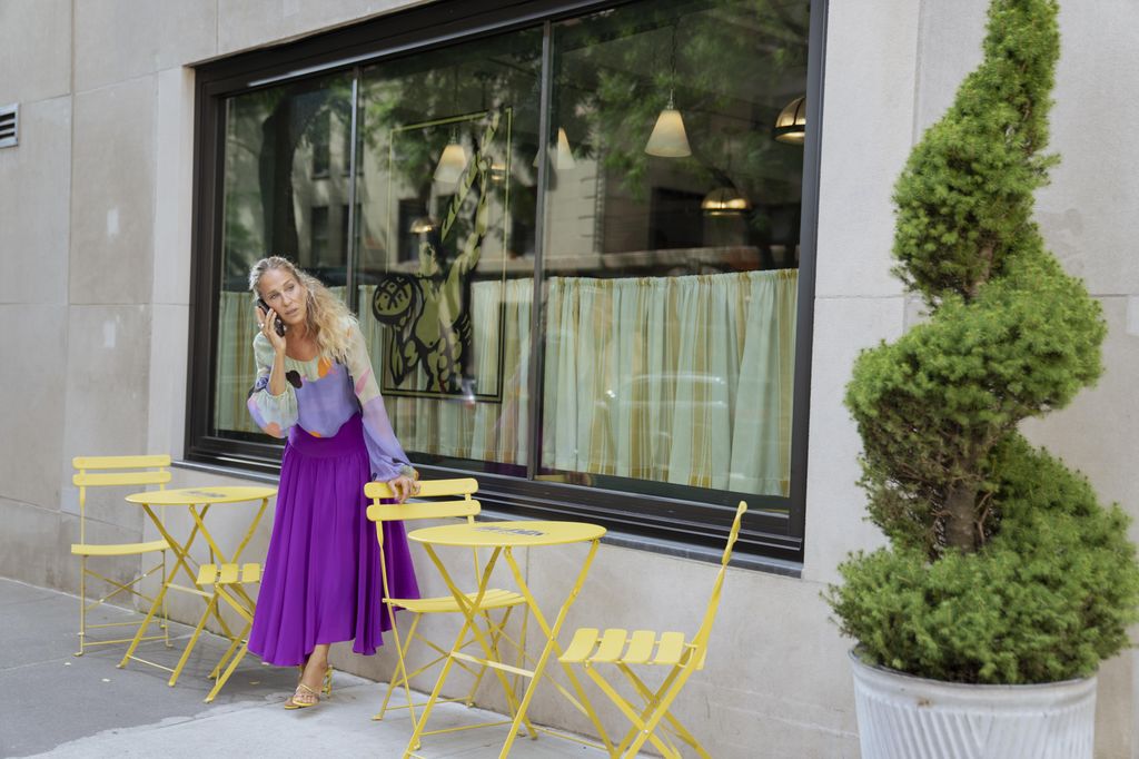 Carrie Bradshaw wearing a purple skirt and multi colored top on And Just Like That