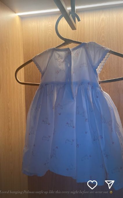 A baby's dress hanging in a wardrobe