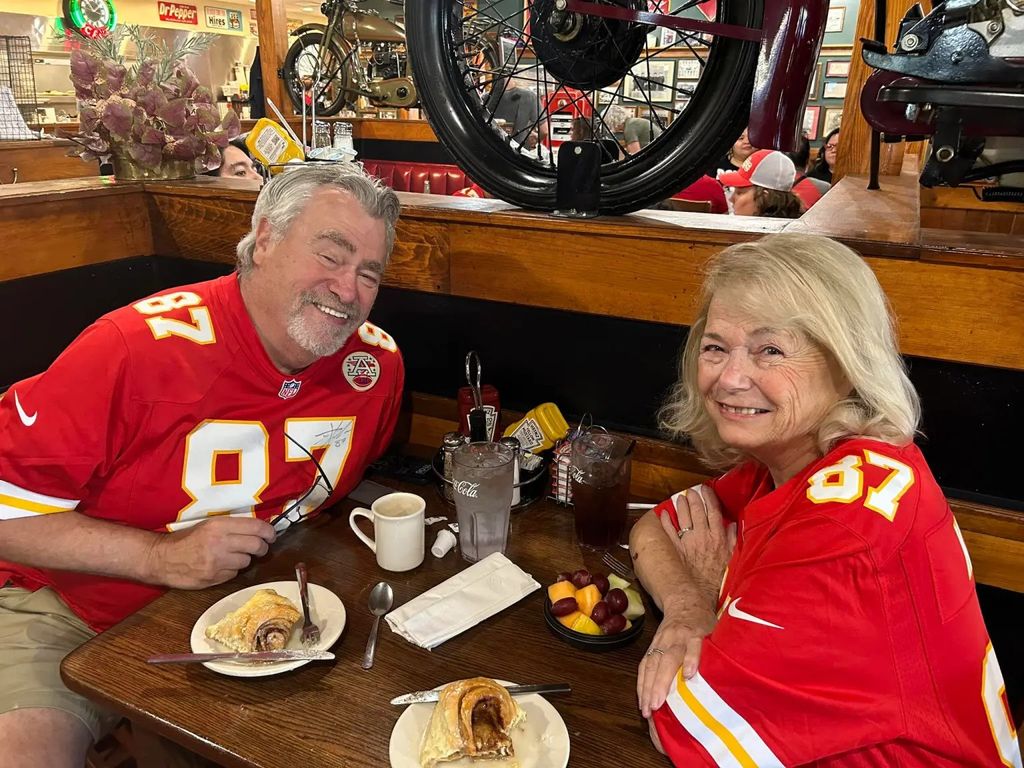 ed kelce and maureen maguire wearing chiefs jerseys