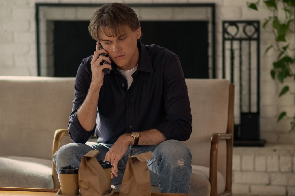 young man sitting on chair talking on phone