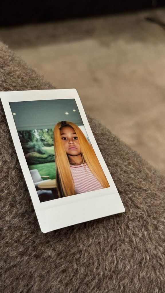 Stormi wearing a peach hued wig