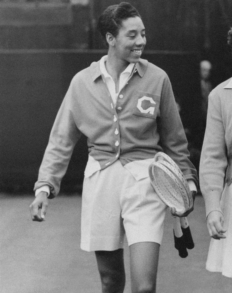 L - R, Althea Gibson of the United States (1927 - 2003) and Patricia Ward of Great Britain (1929 - 1985) walk onto Centre Court for their Women's Singles Second Round match at the Wimbledon Lawn Tennis Championship on 26th June 1951 at the All England Lawn Tennis and Croquet Club in Wimbledon, London, England. Althea Gibson won the match  6 - 0, 2 - 6, 6 - 4. Althea Gibson become the first African American player to win a Grand Slam singles title by winning the 1956 French Open and repeated that feat at the 1957 and 1958 Wimbledon and United States Open Championships. (Photo by Douglas Miller/Keystone/Hulton Archive/Getty Images)