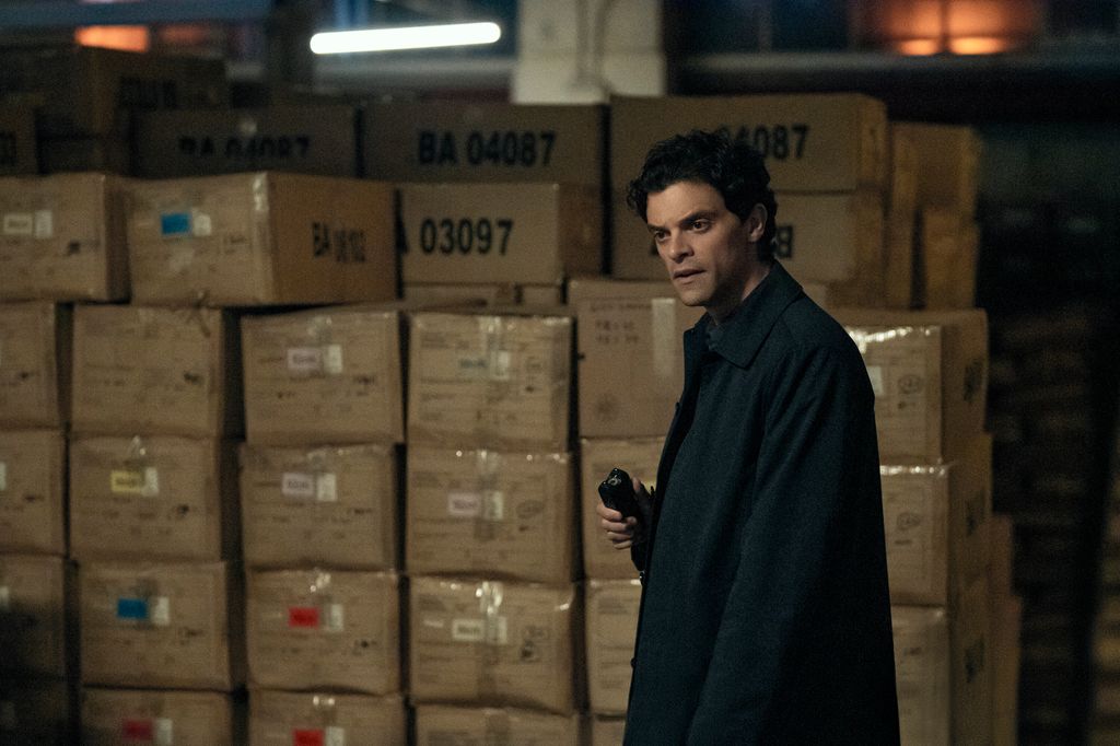 man in long black coat in warehouse