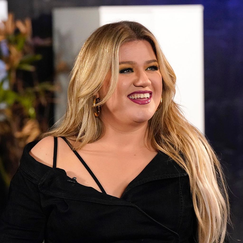 Kelly Clarkson smiling wearing plum lipstick
