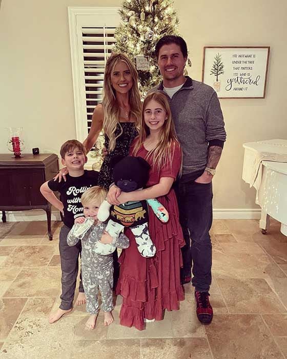 Christina Josh and their three children standing by their Christmas tree