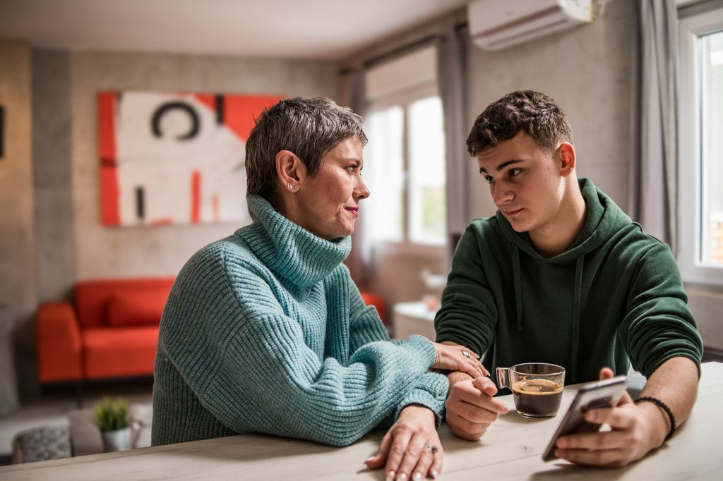 A mother and son are sitting at home and talking