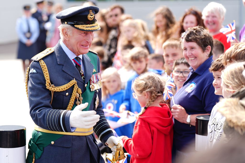 King Charles smiling as he meets RAF soldiers and their families