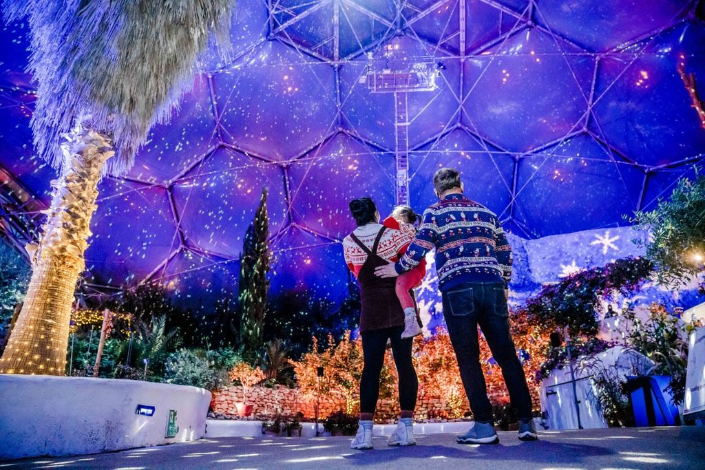 mum dad and daughter inside eden project dome at christmas