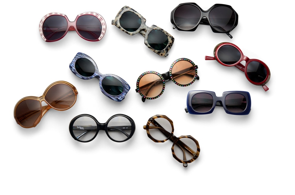 A collection of ten pairs of sunglasses from various designers, including Eyebobs X Iris Apfel, Selima Optique, Emilio Pucci, and Christian Dior. These sunglasses feature different shapes like oversized, round, and rectangular frames, with details like rhinestones, tortoiseshell, and vibrant hues. Each pair is a part of Iris Apfel’s legendary eyewear collection.