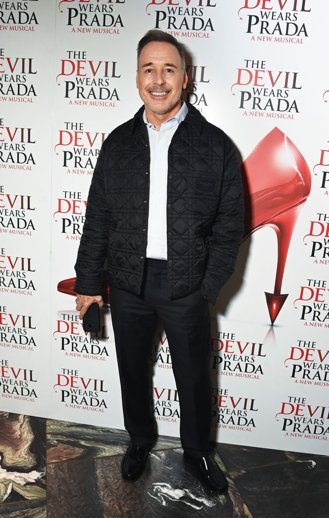 David Furnish wearing a black jacker and trousers for the launch of the Devil Wears Prada cast album